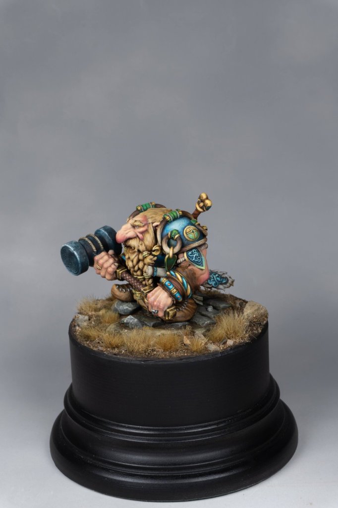 Miniature dwarf figure with telescope on a display base for tabletop gaming.